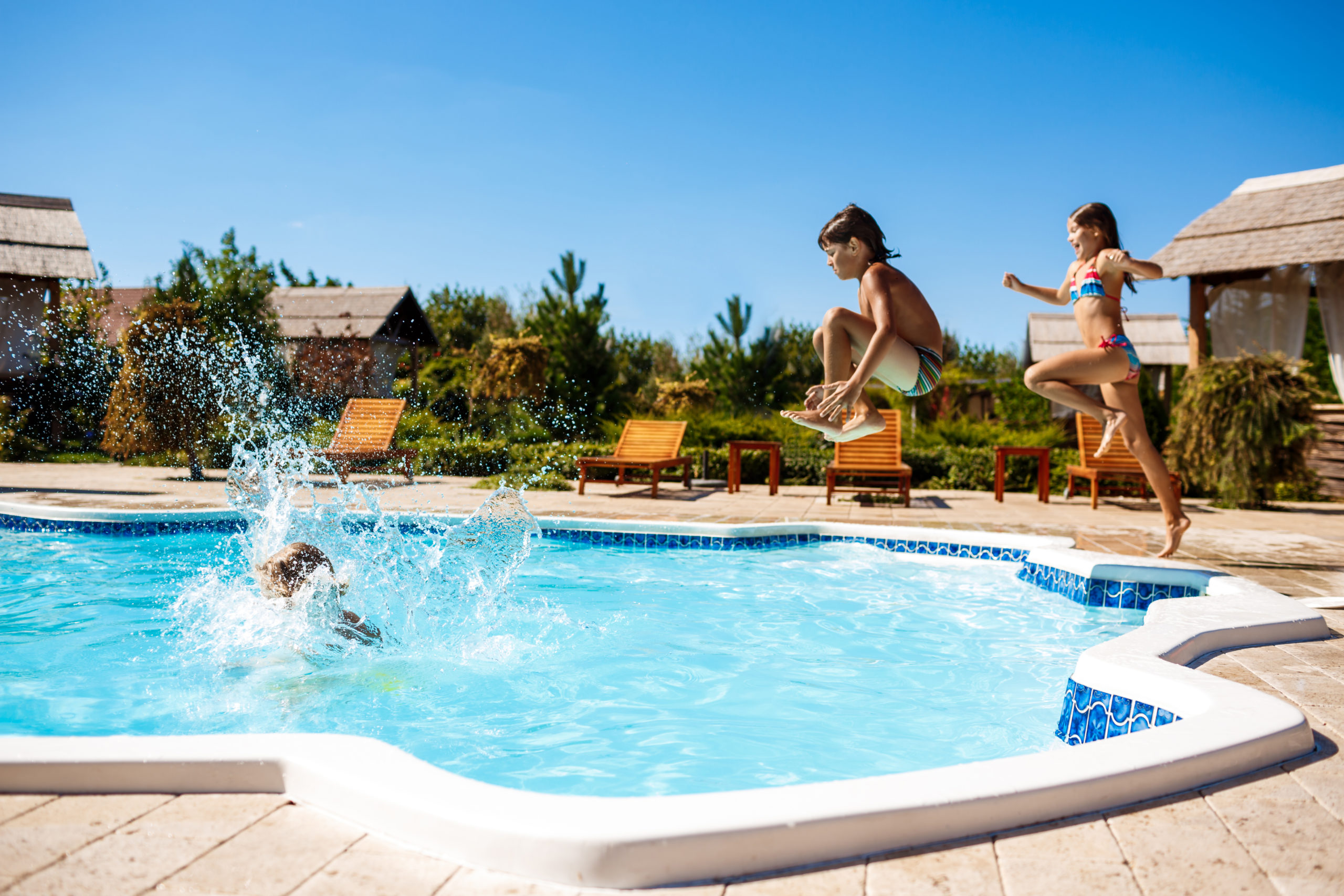 Cheerful children rejoicing, jumping, swimming in pool. Copy space
